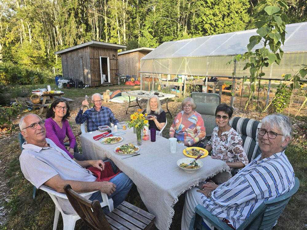 People sitting around a table for a meal in Grafton Gardens near the new Poly Tunnel