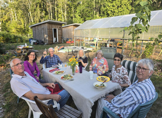 People sitting around a table for a meal in Grafton Gardens near the new Poly Tunnel